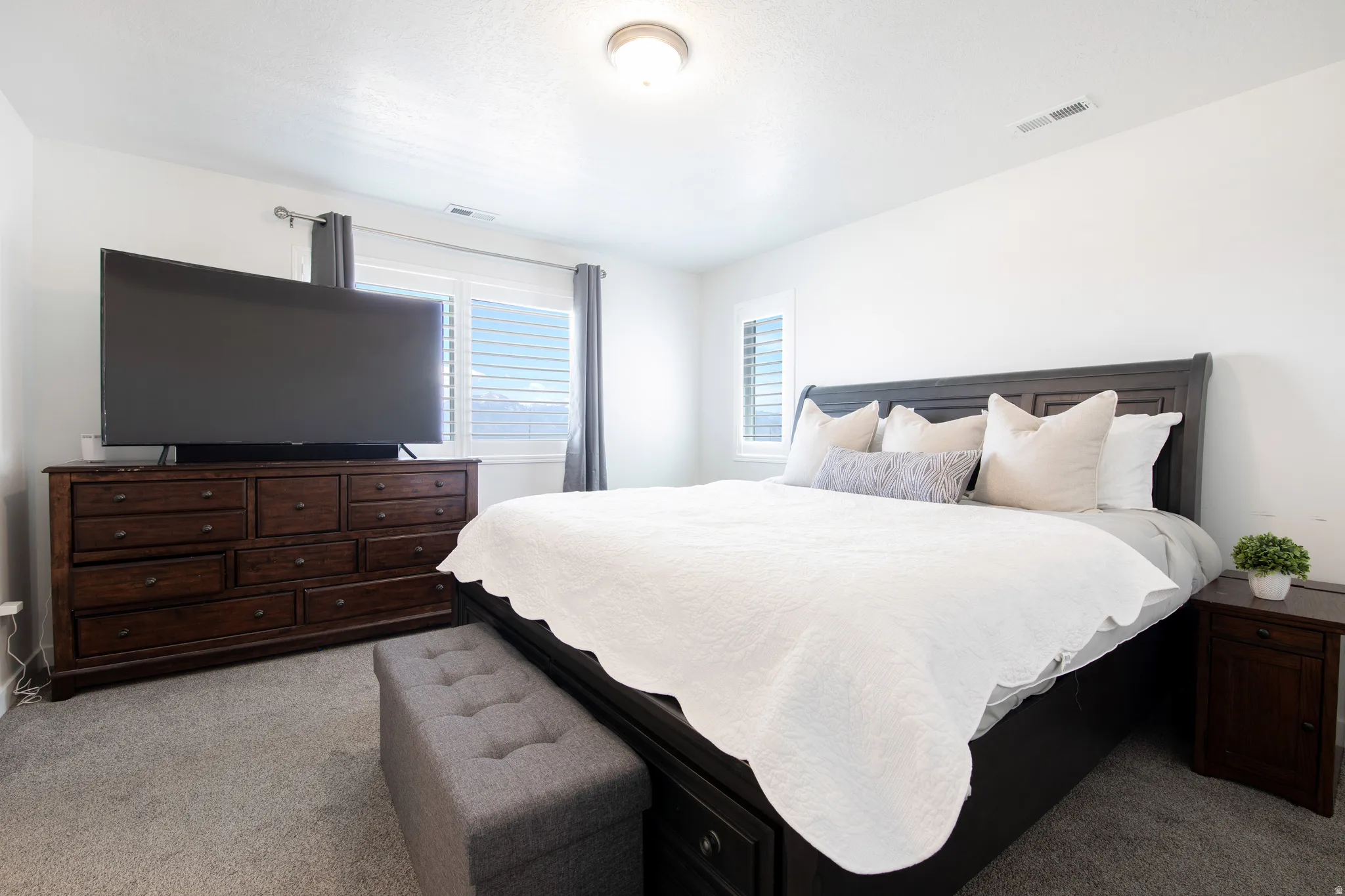 Spacious room featuring plush gray carpeting and white walls