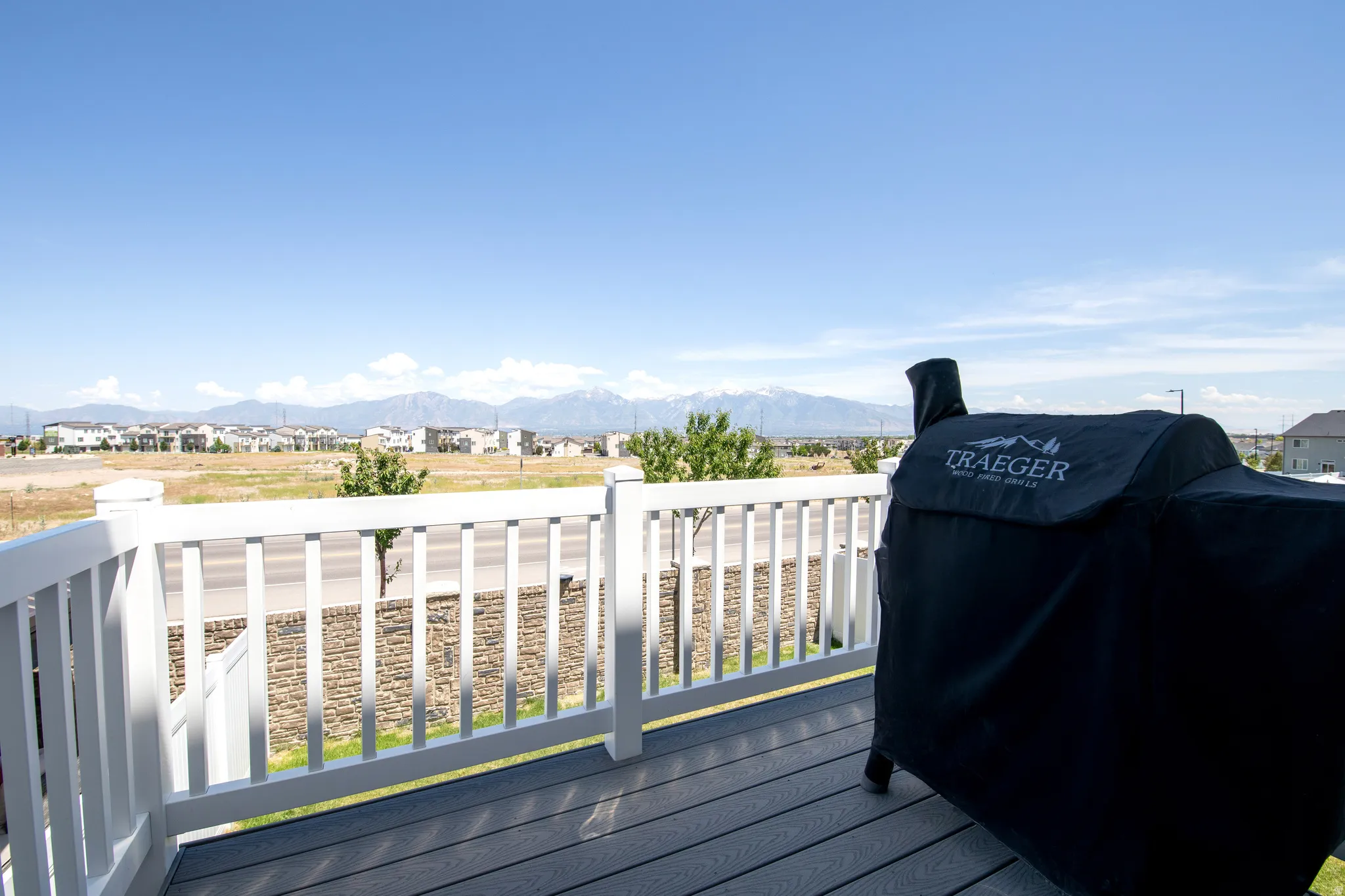 Expansive outdoor deck featuring composite decking, white railing, and a broad mountain backdrop