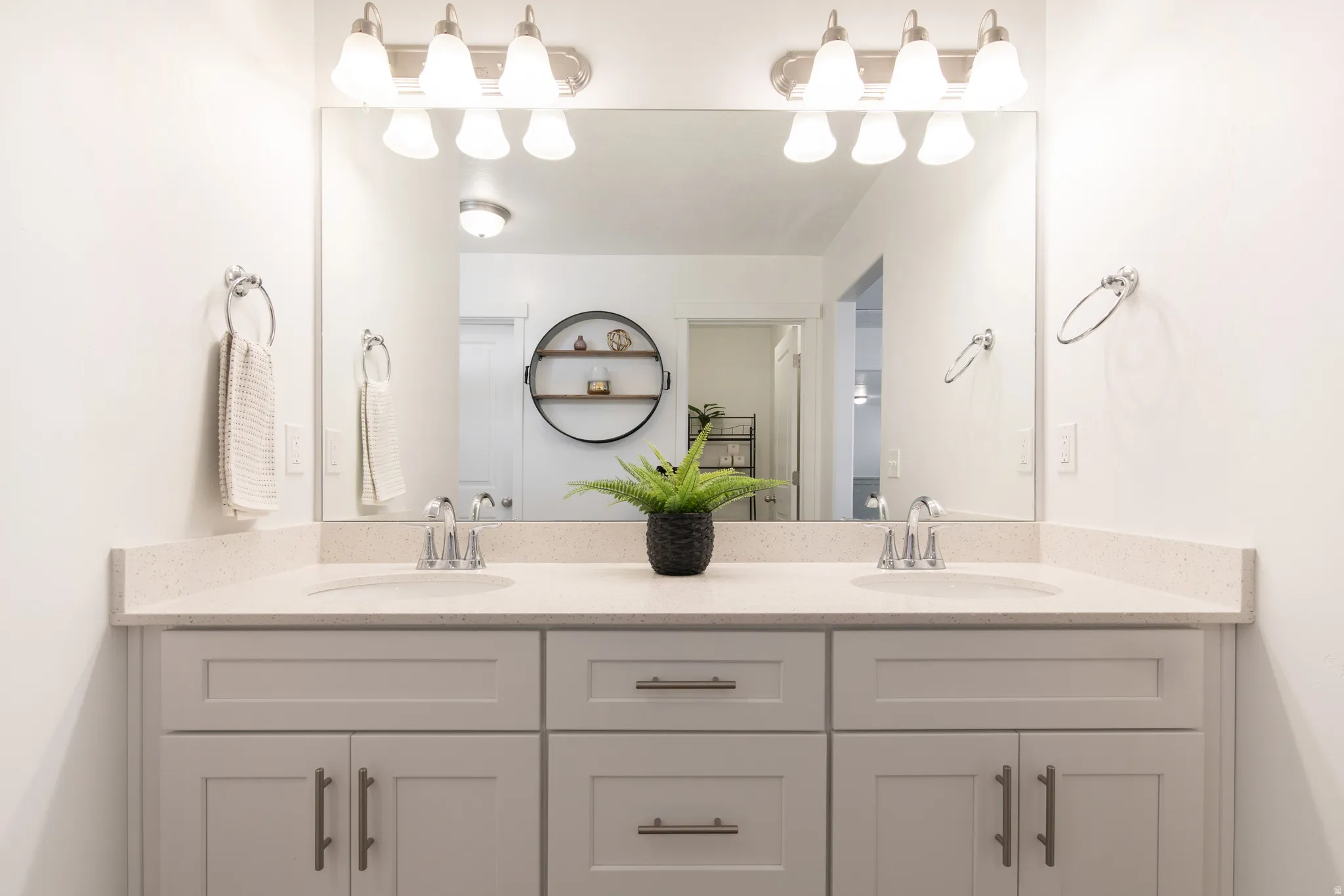 Double vanity with light gray shaker style cabinetry, brushed nickel hardware, and a light-toned countertop