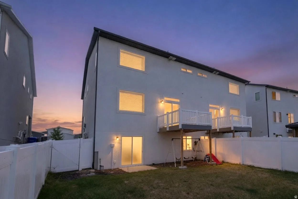 White stucco exterior with multiple windows and two elevated balconies featuring white railings