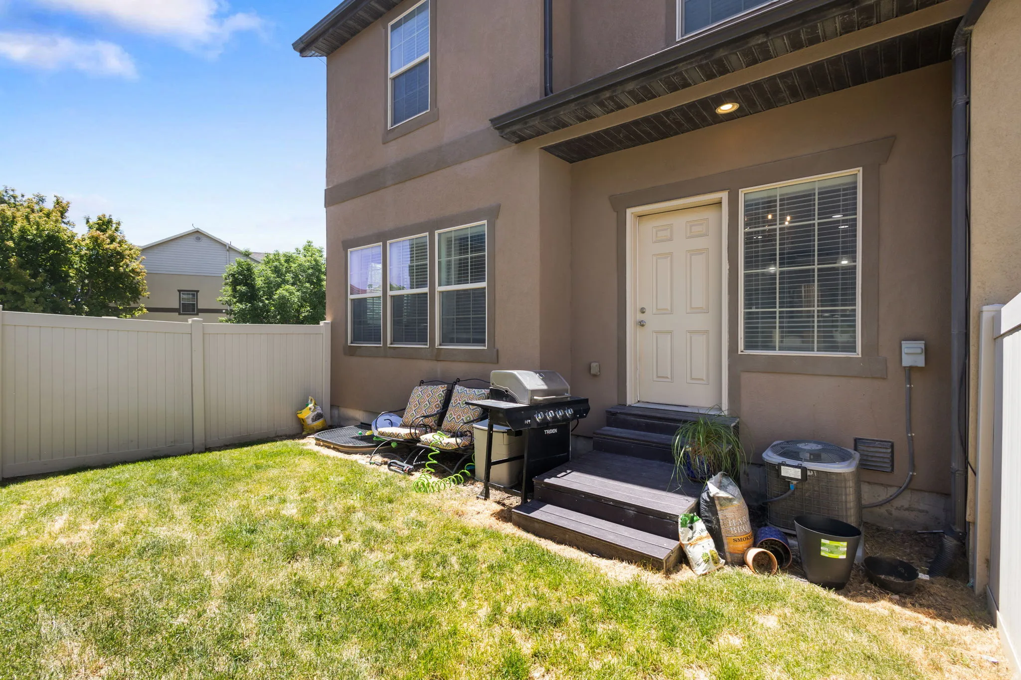 Private fenced yard with a multi-paned window, a white paneled door, and a three-step landing