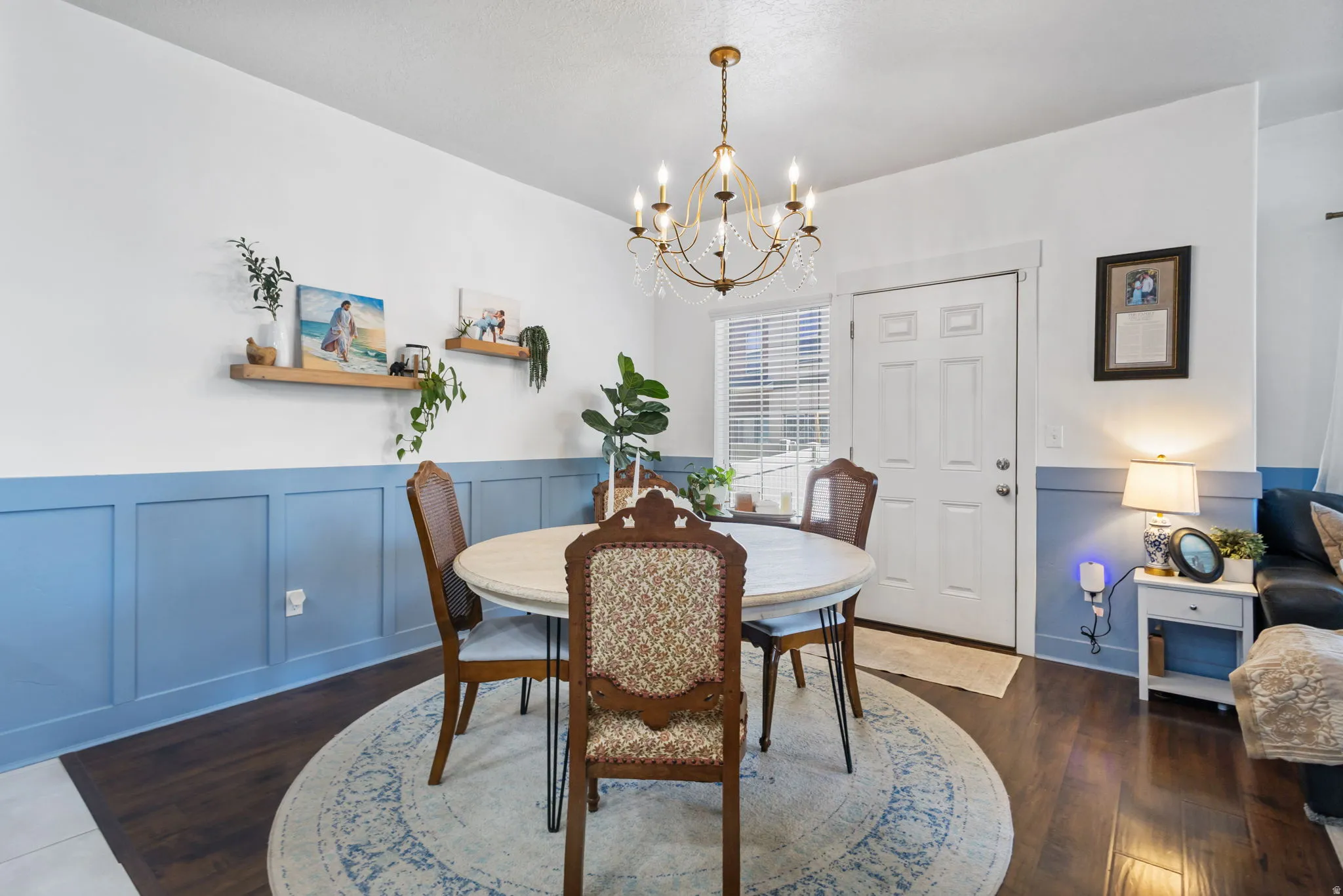 Dining area featuring a decorative chandelier, white paneled door with window, and wood-finish flooring