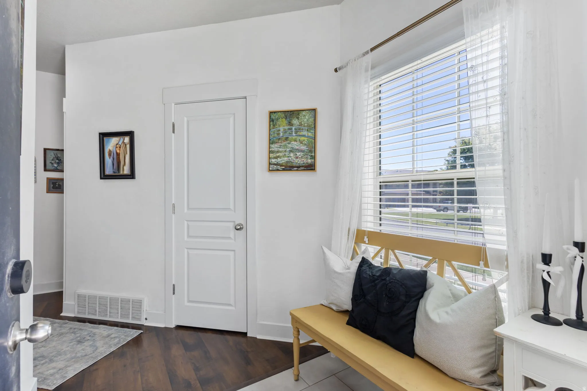 Entryway featuring dark wood-finish flooring, white baseboards, and a white interior door with panel detailing