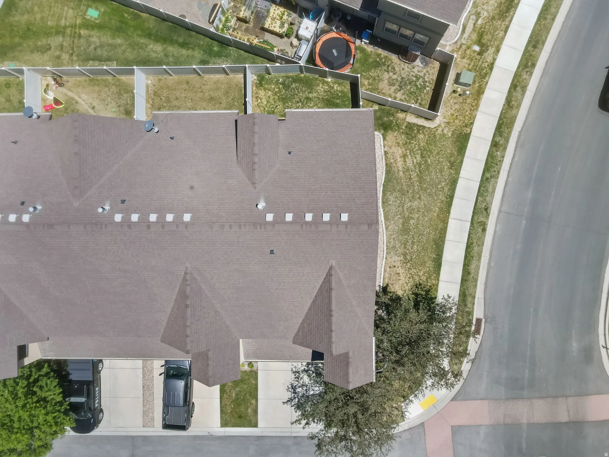 Townhome property featuring a brown shingle roof, paved driveway, and dedicated carport