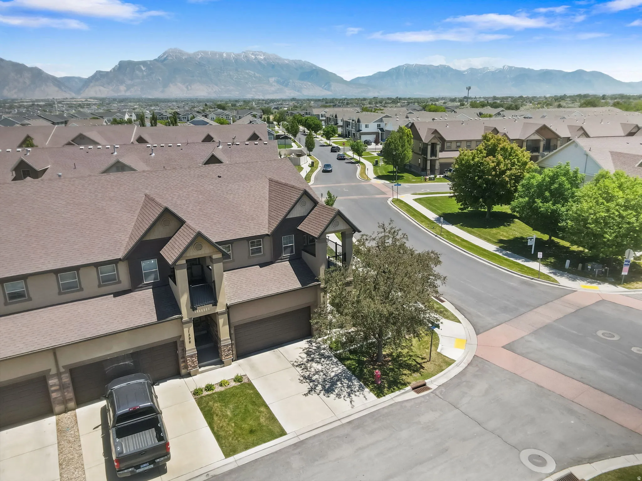 Townhome exterior featuring multi-toned siding, attached garages, and a paved driveway