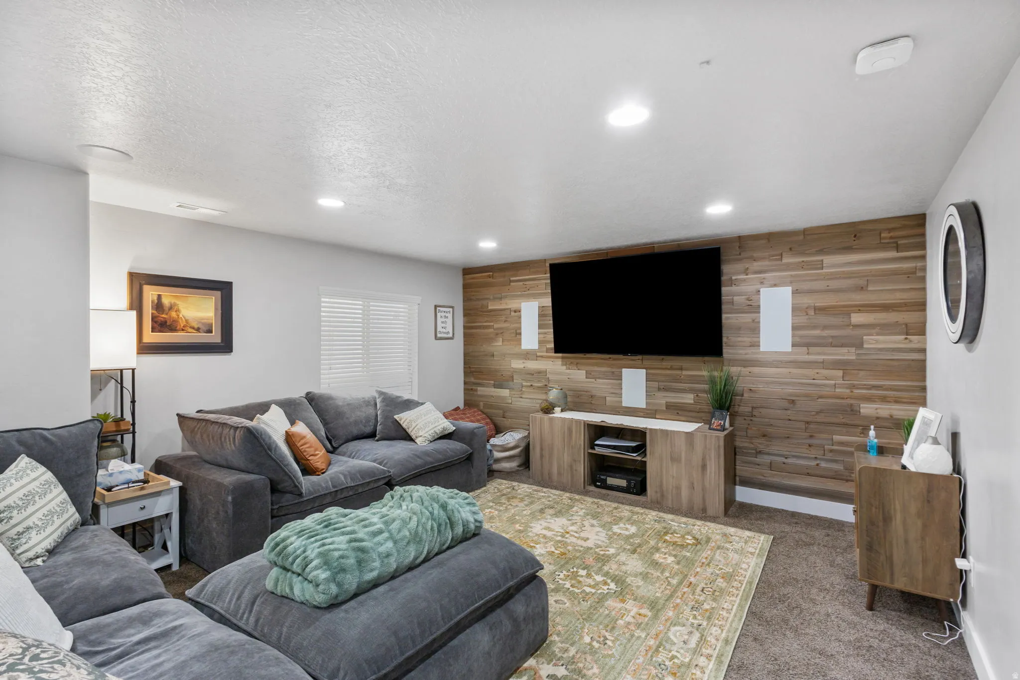Entertainment room featuring a wood-panel accent wall, recessed lighting, and carpet flooring
