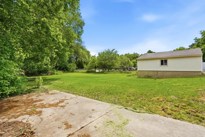 Expansive grassy yard with mature trees