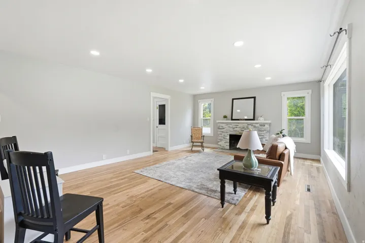 Spacious interior room featuring light wood-finish flooring, recessed lighting, and ample natural light from multiple windows