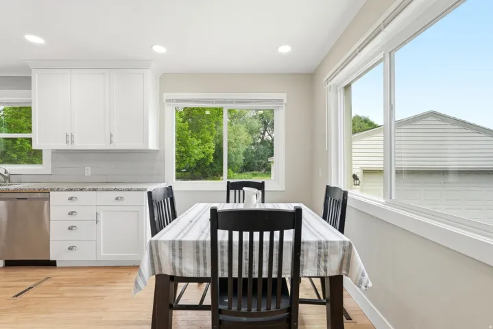 Bright dining area featuring wood-finish flooring, recessed lighting, and large windows