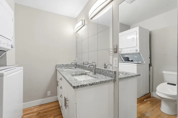 Dual vanity with granite-style countertop, undermount sinks, and chrome faucets