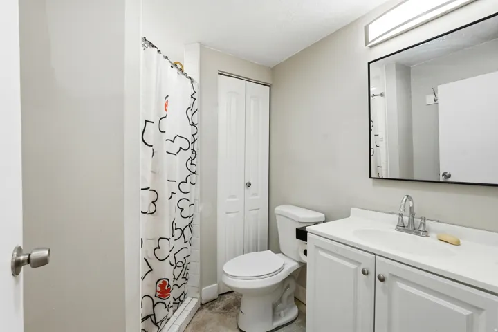 Bathroom featuring a white vanity with integrated sink, chrome faucet, and rectangular framed mirror