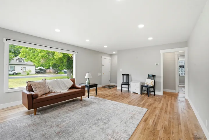Spacious living area featuring light wood-finish flooring, recessed lighting, and light gray wall paint