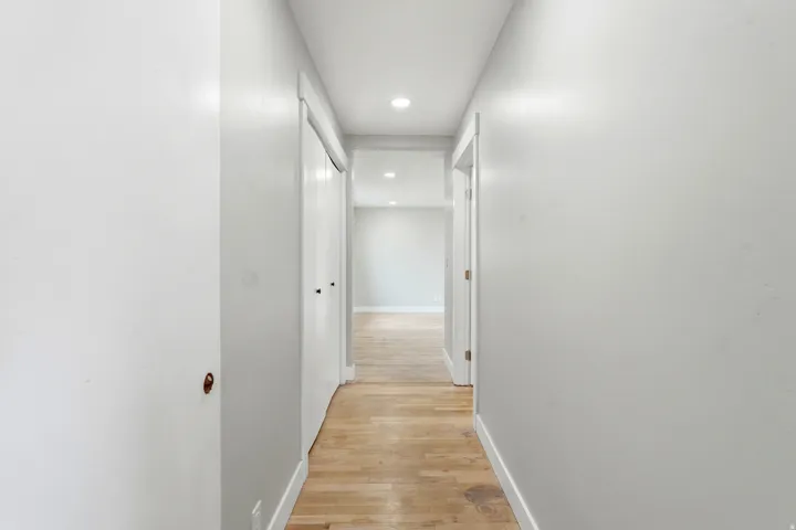 Hallway featuring recessed lighting, light wood-finish flooring, white walls, and bright white trim