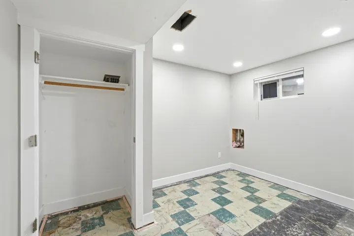 Interior room featuring a built-in closet with shelving, recessed ceiling lighting, and a window with blinds
