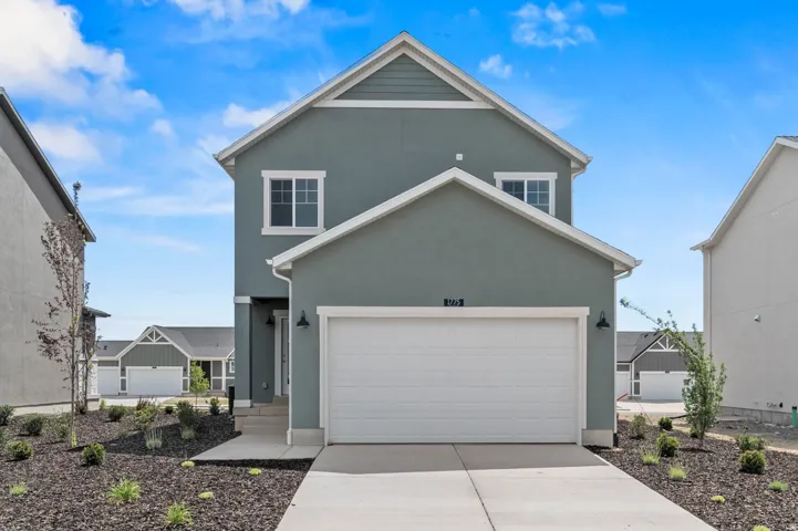 Contemporary two-story residence featuring a two-car garage, light gray stucco exterior, white trim, and a gabled roof