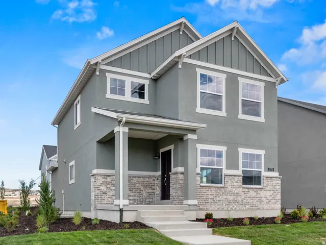 Contemporary two-story residence with a gray stucco facade and light brick accents