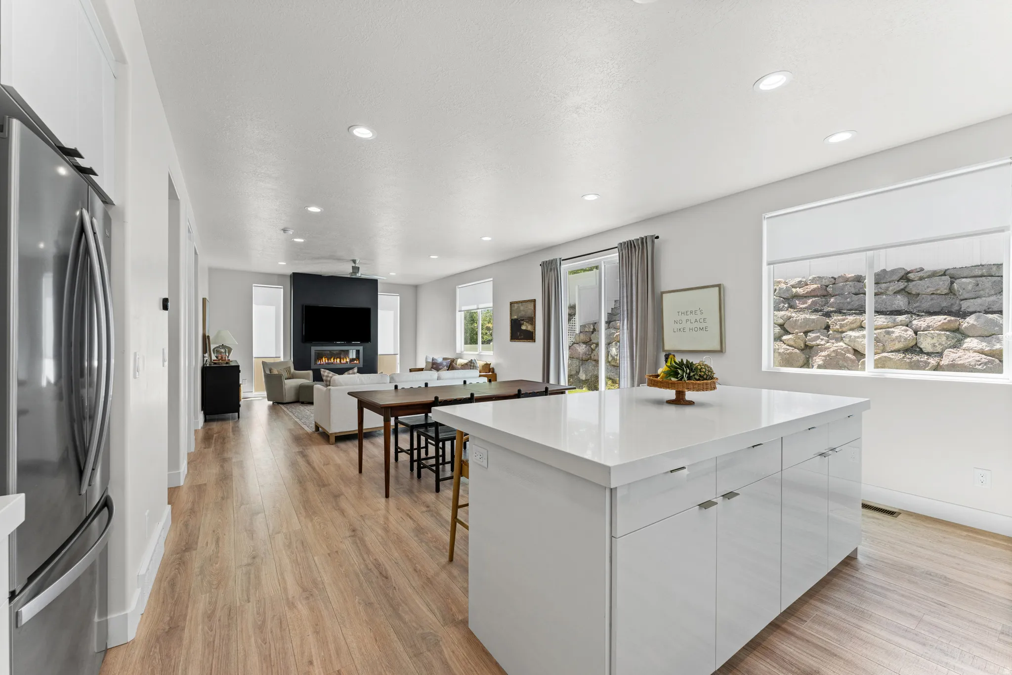 Bright open-concept living space featuring wood-finish flooring, recessed lighting, and white walls