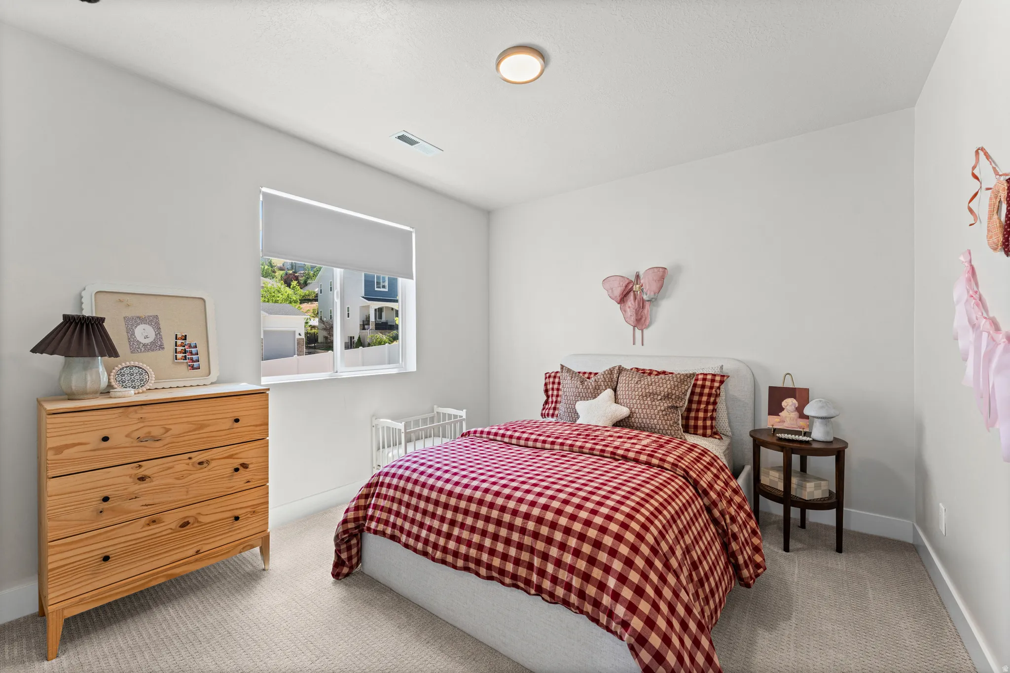 Neutral wall paint, light-colored carpet flooring, recessed lighting, and a single window with roller shade