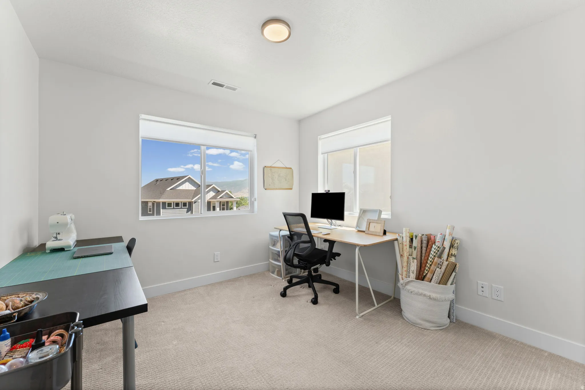 Spacious room featuring neutral carpeting, light-colored walls, and two large windows with white blinds