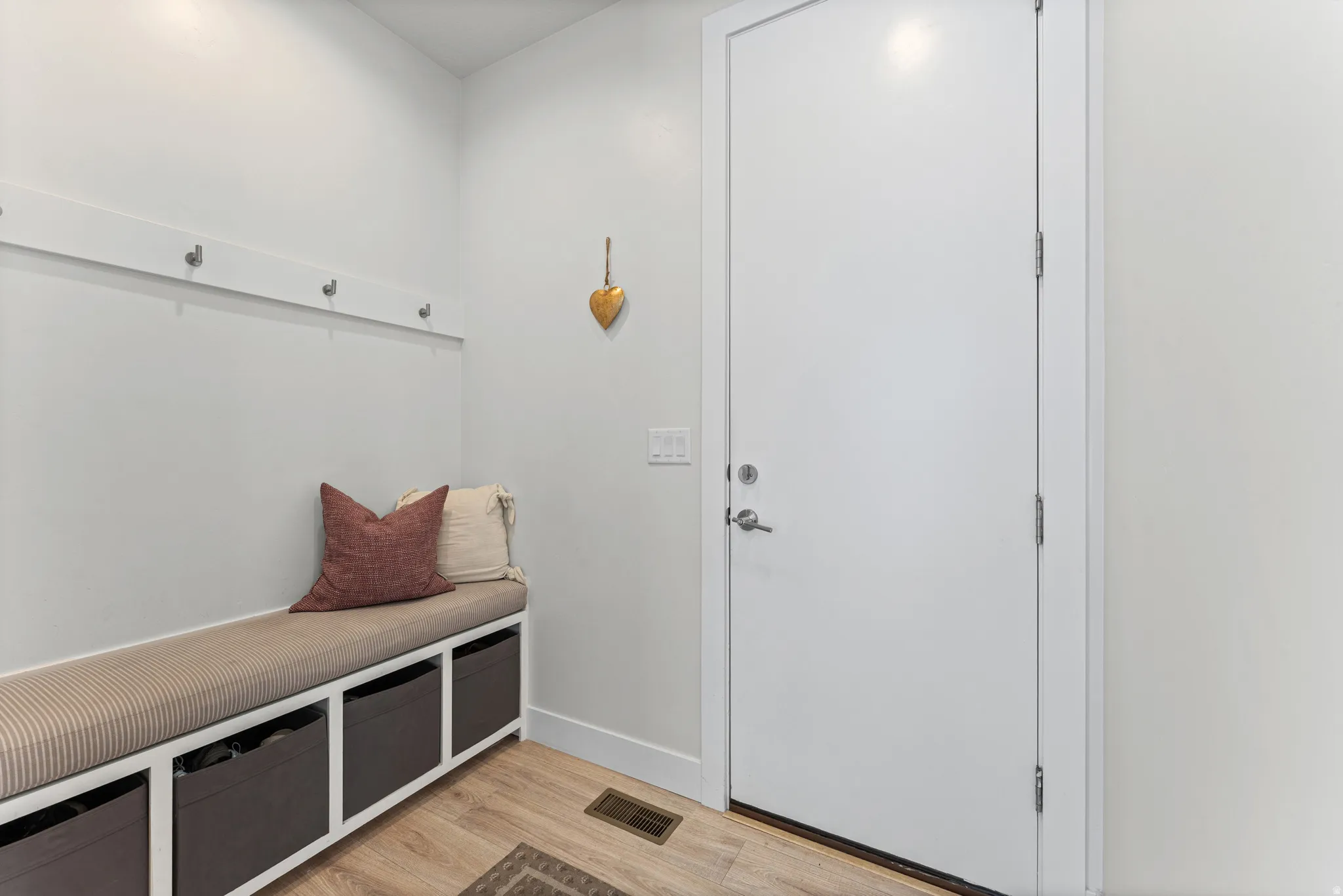 Entryway with wood-finish flooring and a built-in bench featuring cubby storage