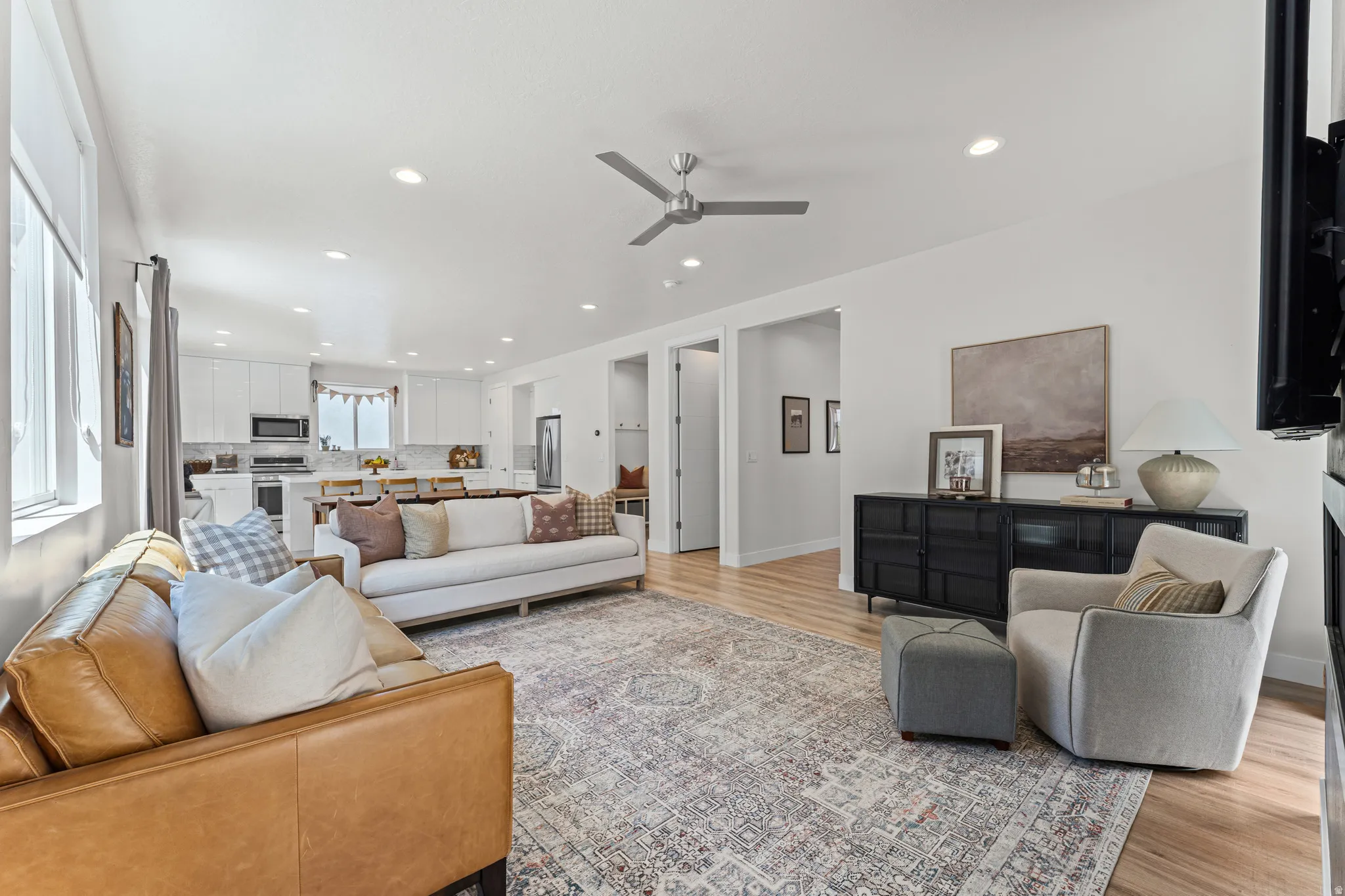 Open-concept living area featuring wood-finish flooring, recessed lighting, and a contemporary ceiling fan