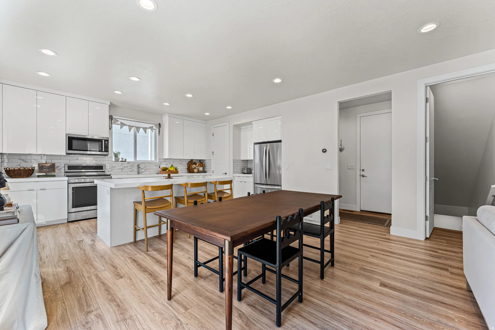 Open-concept kitchen and dining area featuring wood-finish flooring