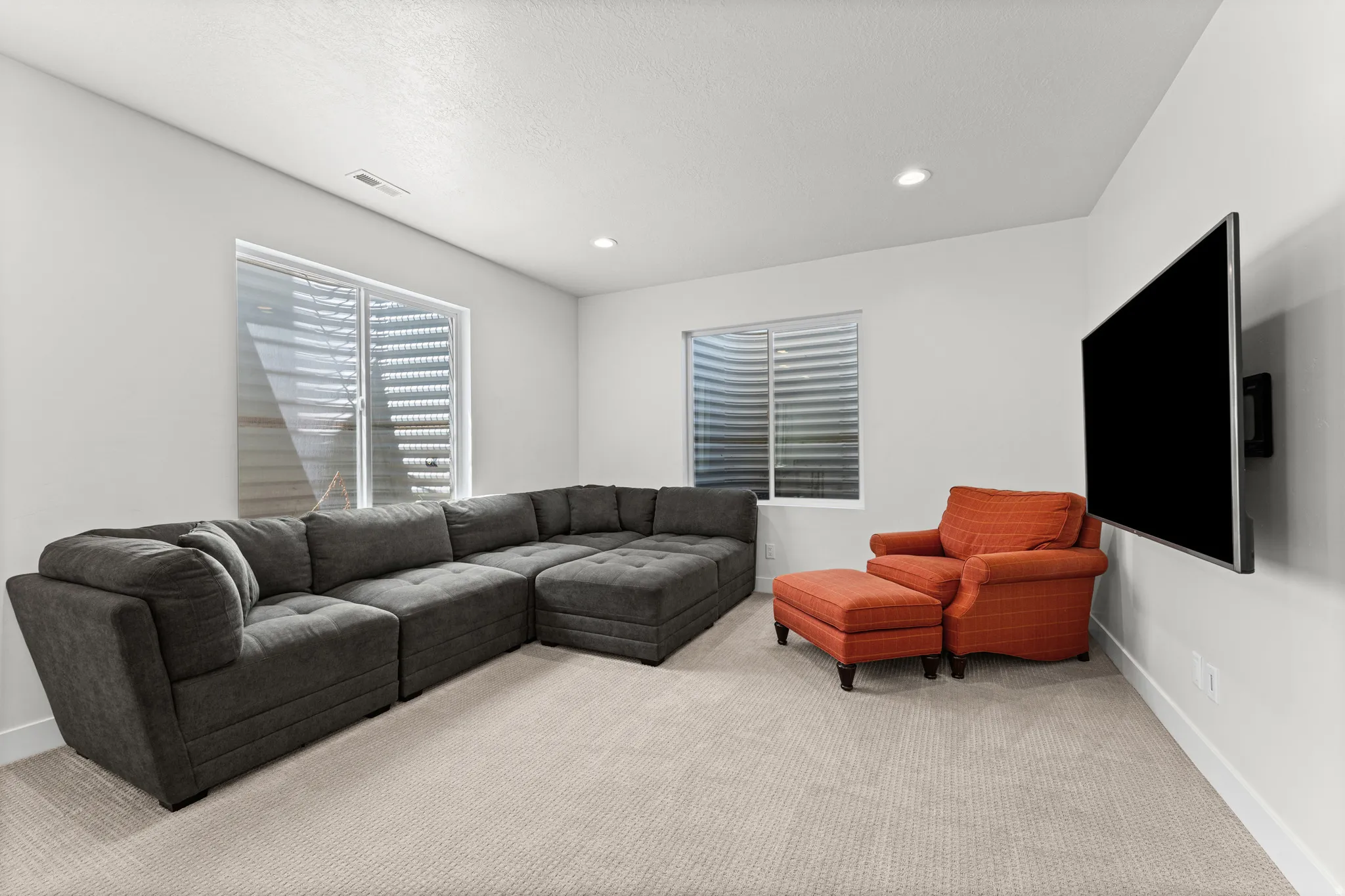 Carpeted room with white walls, recessed lighting, and two windows