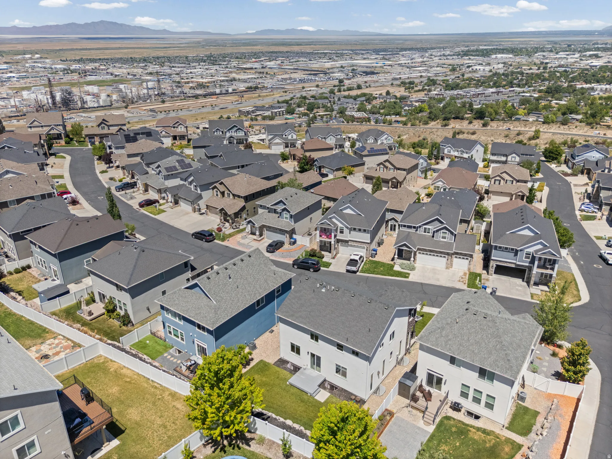 Aerial view of a residential neighborhood with diverse architectural styles, paved streets, and varied landscaping