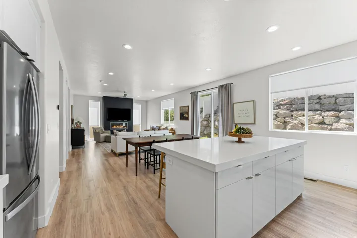 Bright open-concept living space featuring wood-finish flooring, recessed lighting, and white walls
