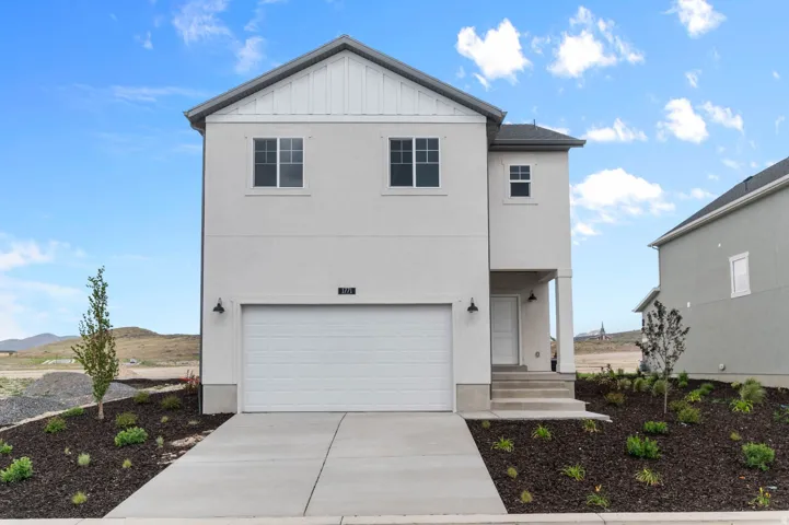 Contemporary two-story residence featuring a white stucco exterior and a contrasting dark gray roof