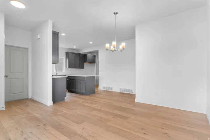 Open concept layout featuring wood-finish flooring, recessed lighting, and a modern chandelier
