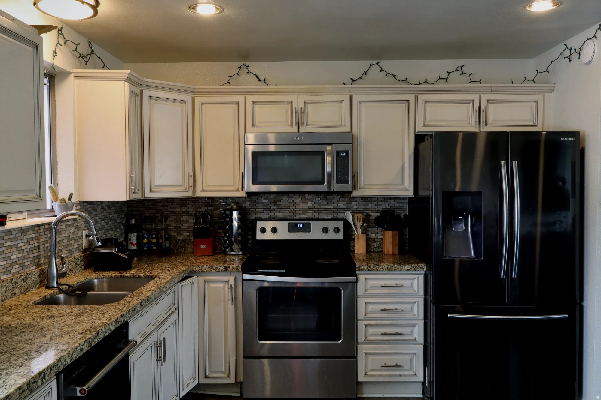 Kitchen featuring a stainless steel undermount sink, granite countertops, and a mosaic tile backsplash