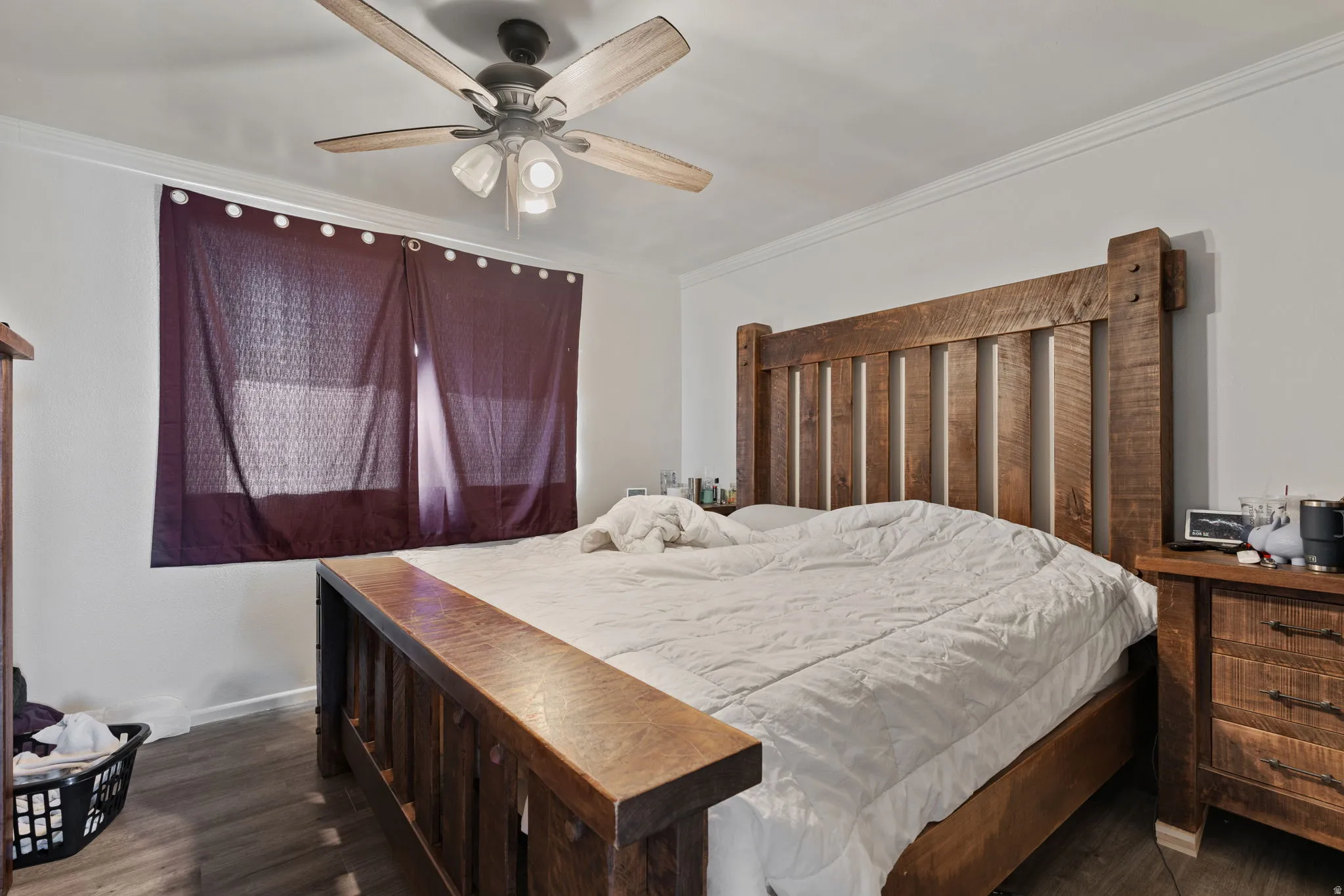 Spacious room featuring wood-finish flooring, white walls, and a ceiling fan with integrated lighting