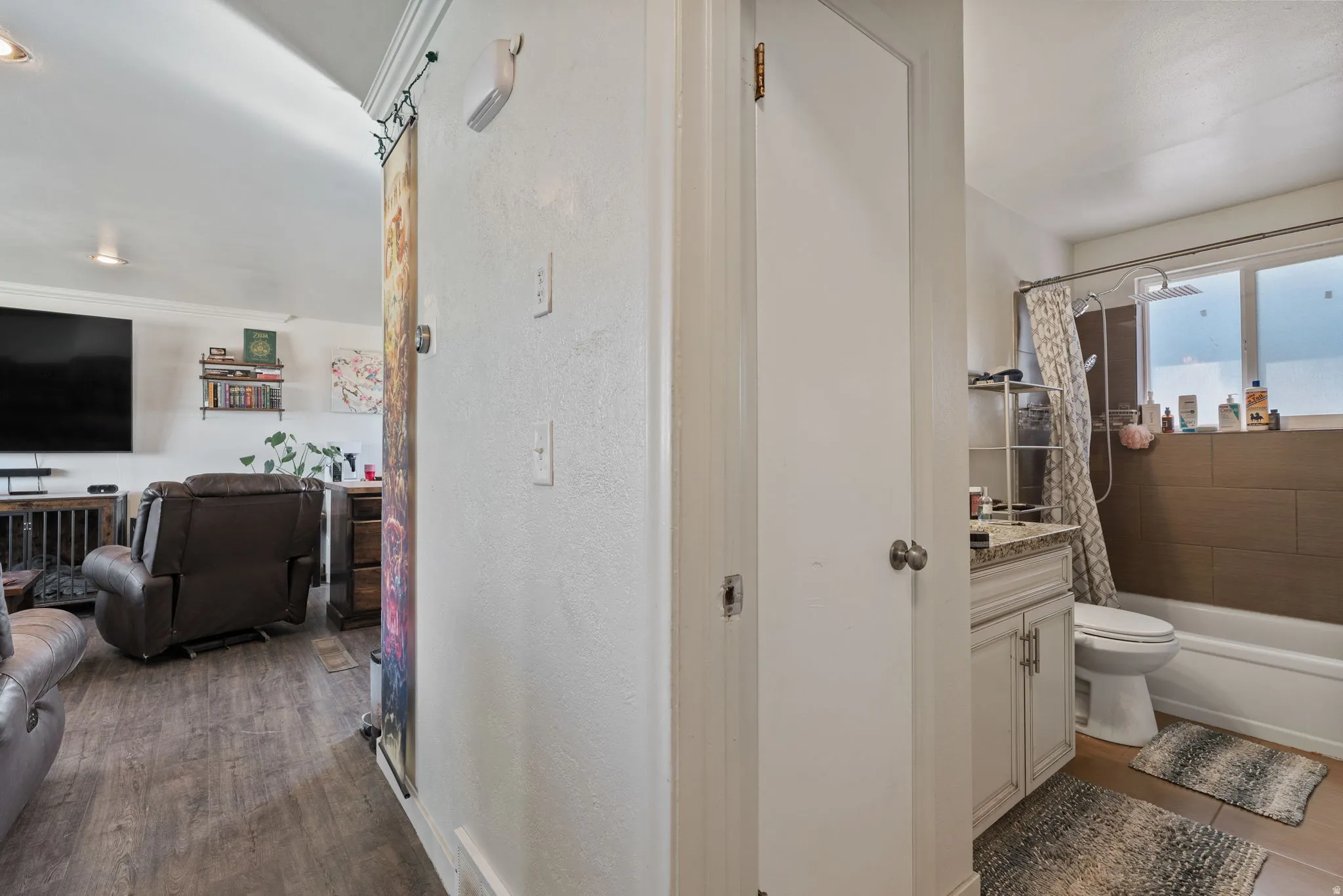 Bathroom featuring a full-size bathtub, shower with a curved rod, and a window with privacy glass