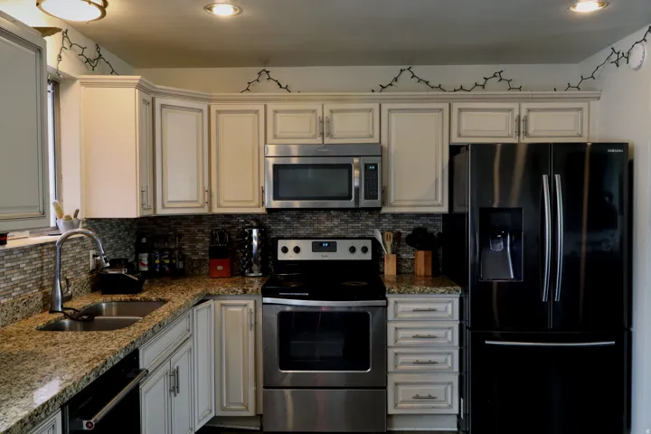 Kitchen featuring a stainless steel undermount sink, granite countertops, and a mosaic tile backsplash