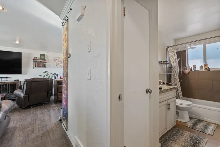 Bathroom featuring a full-size bathtub, shower with a curved rod, and a window with privacy glass