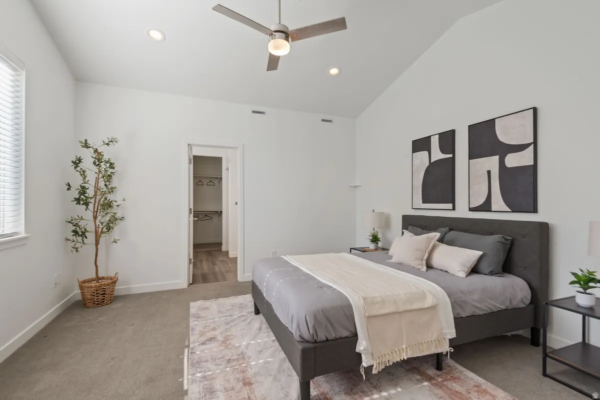 Vaulted ceiling bedroom with recessed lighting, ceiling fan, and carpet flooring