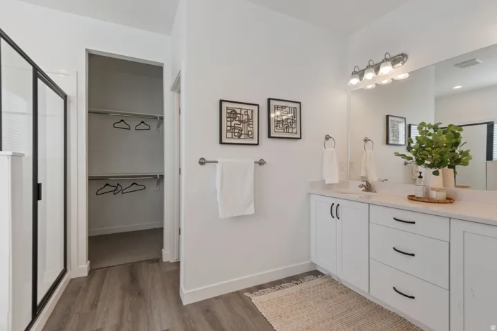 Bathroom featuring a dual vanity with white cabinetry and a light-toned countertop