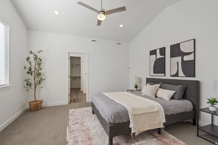 Vaulted ceiling bedroom with recessed lighting, ceiling fan, and carpet flooring