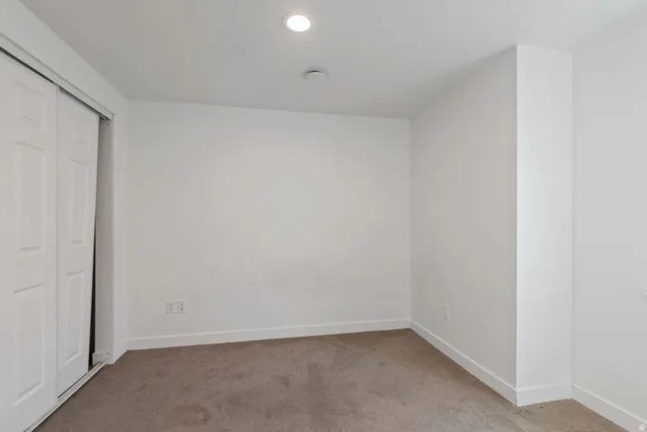 Room featuring carpet flooring, white walls, white baseboards, and a recessed ceiling light