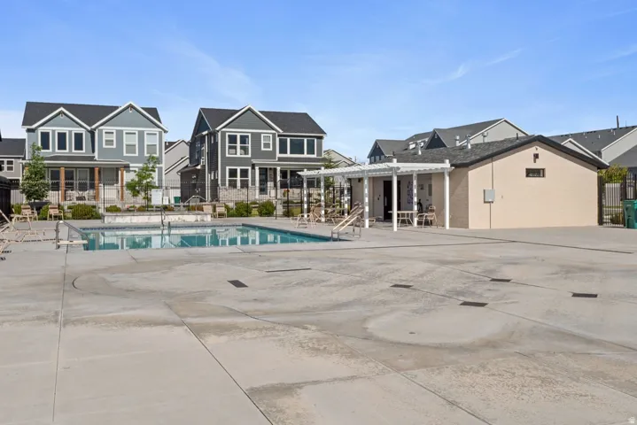 Outdoor swimming pool with integrated steps, surrounded by a concrete deck and bordered by a low stone wall