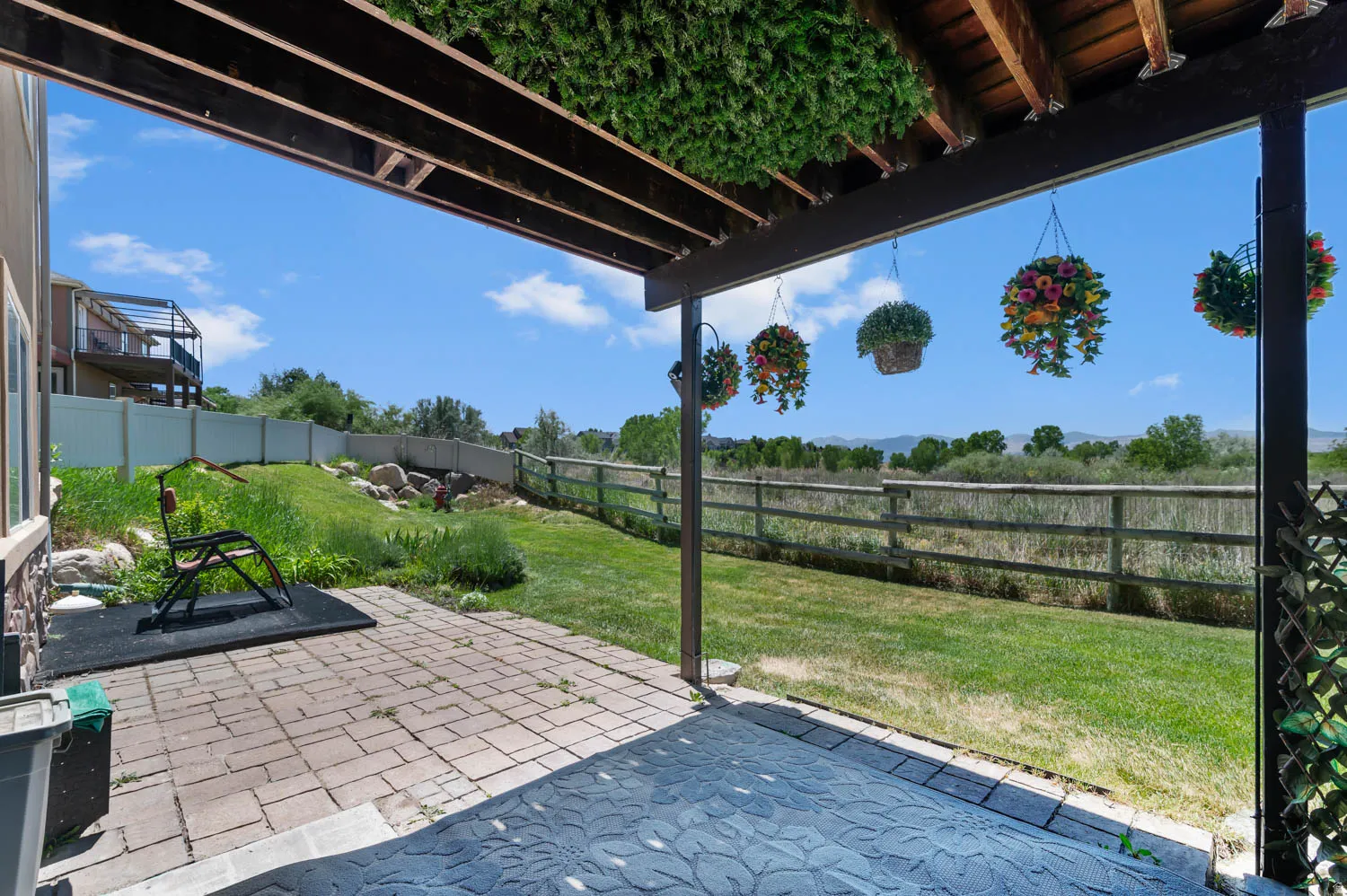 Covered patio featuring paver stones and wood beam construction