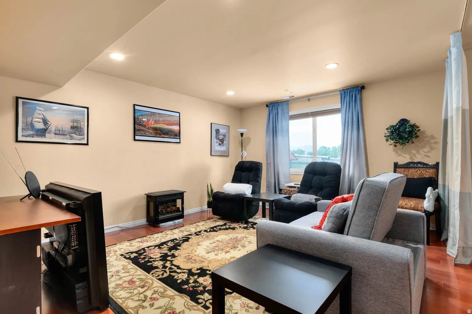 Living area featuring wood-finish flooring, recessed lighting, and a window with exterior visibility