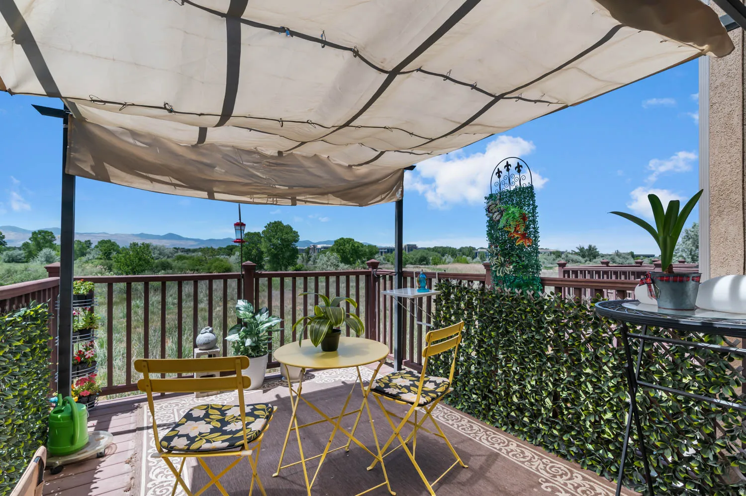 Outdoor deck featuring a fabric canopy, wood railing, and a scenic mountain backdrop