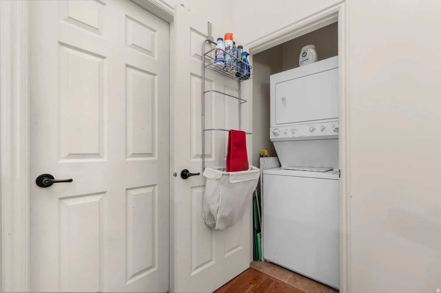 Dedicated laundry closet featuring a white stacked washer and dryer unit