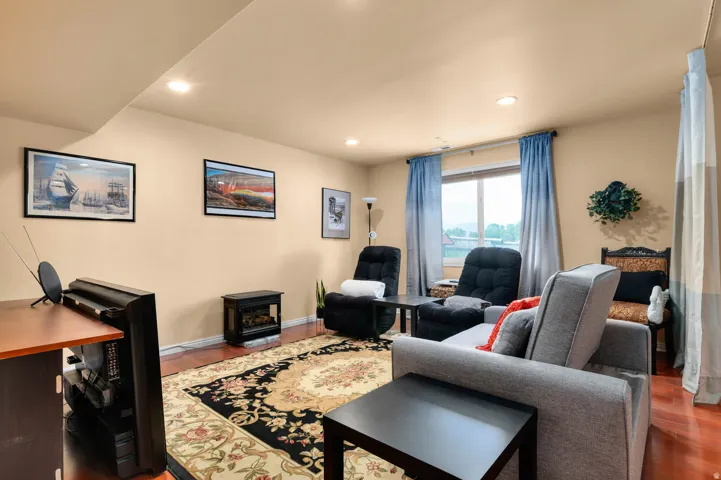 Living area featuring wood-finish flooring, recessed lighting, and a window with exterior visibility