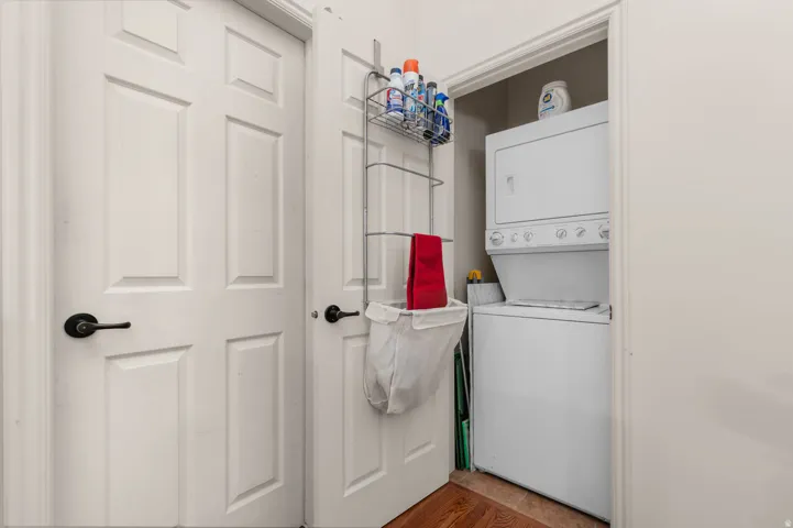 Dedicated laundry closet featuring a white stacked washer and dryer unit