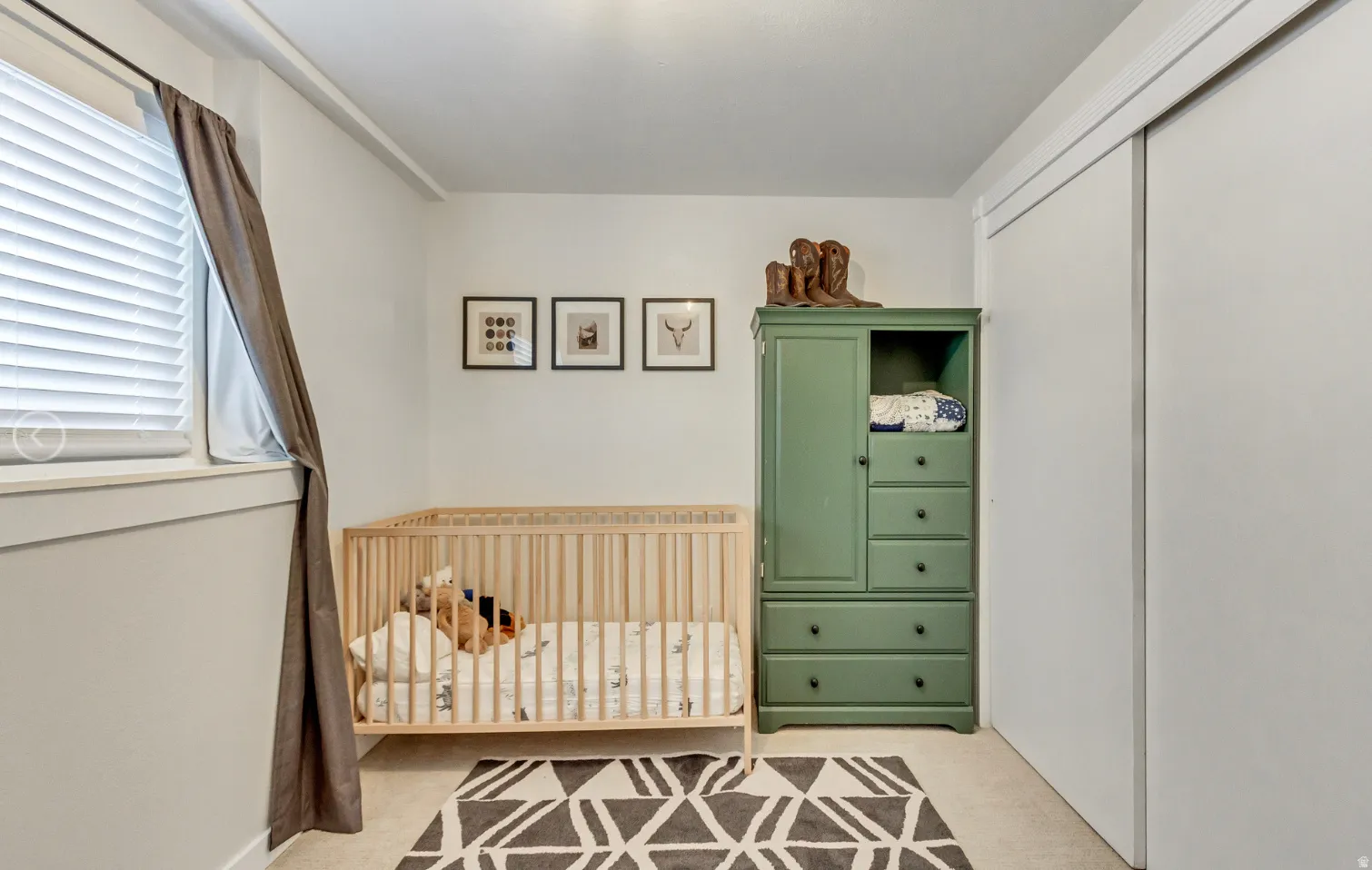 Room featuring light neutral wall paint, a window with horizontal blinds and drapes, and carpeted flooring