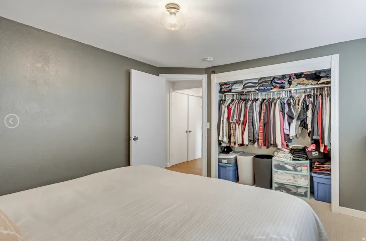 Bedroom with light gray textured walls and a ceiling-mounted light fixture
