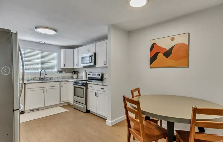 Modern kitchen with white cabinetry, stainless steel appliances, and light-toned countertops